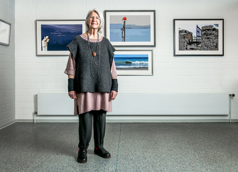 Foto der Künstlerin Karen Seggelke, in dem Ausstellungsraum on the sea shore Galerie Tobien Husum. Sie schaut direkt in die Kamera.